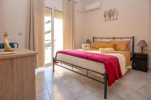 um quarto com uma cama com um cobertor vermelho em Rodini Sun Apartment in Ilha de Rhodes