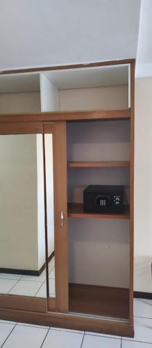 a book shelf with a clock on it at Nallah ApartHotel in Natal