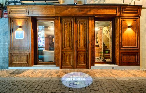 un magasin avec des portes en bois dans une rue dans l'établissement Santa Rita Rita B&B, à Talavera de la Reina