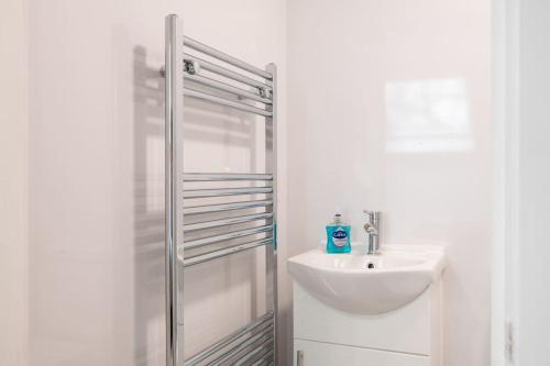 a white bathroom with a sink and a shower at Modern Studio: Old Trafford in Manchester