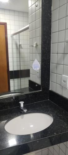 a bathroom counter with a sink and a mirror at Nallah ApartHotel in Natal