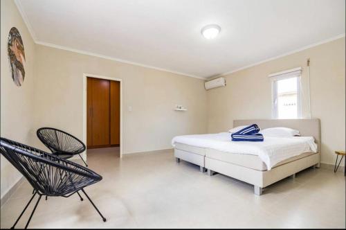 een slaapkamer met een bed en een stoel erin bij Island Oasis Villa in Noord