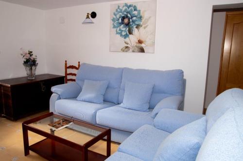 比利亞卡里略的住宿－Casa rural El Tejar，客厅配有蓝色的沙发和茶几