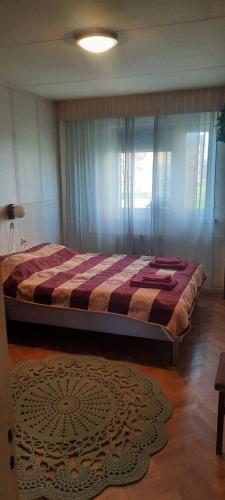 a large bed in a bedroom with a window at Külaliskorter Põlvas in Põlva