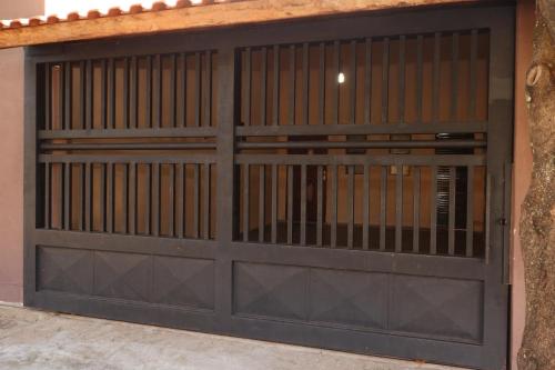 a garage door with a metal gate at Casa de Temporada RA Olímpia in Olímpia