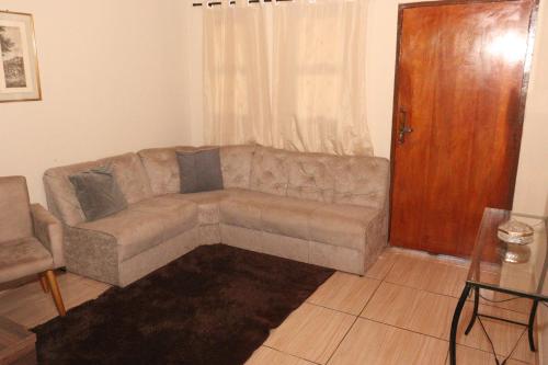 a living room with a couch and a door at Casa de Temporada RA Olímpia in Olímpia