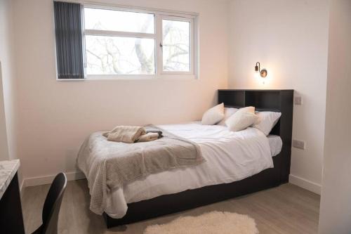 sypialnia z dużym łóżkiem i oknem w obiekcie Homely Studio: Old Trafford w Manchesterze