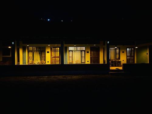 a building lit up at night with windows at Gaonvasi Homestay in Uttarkāshi