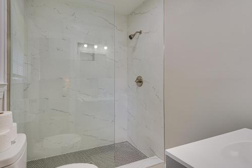 ein weißes Bad mit einer Dusche und einer Glastür in der Unterkunft Charming Hanahan Home 10 Mi to Charleston! in Charleston