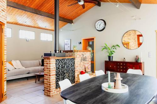 a living room with a table and a clock on the wall at Authentic house with playroom and infrared sauna in Bilzen