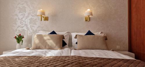 - une chambre avec un lit doté de draps blancs et d'oreillers bleus dans l'établissement Apartment Medea 1 with private parking, à Opatija