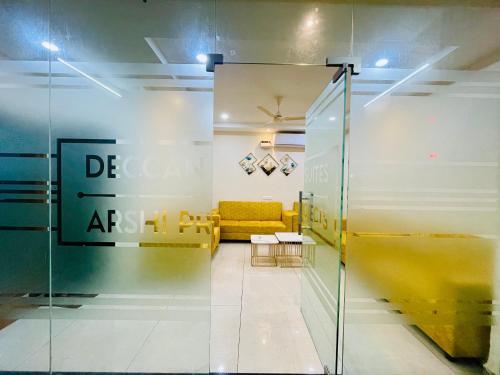 a lobby with a yellow couch in a room at Deccan Suites, Tirupati in Tirupati