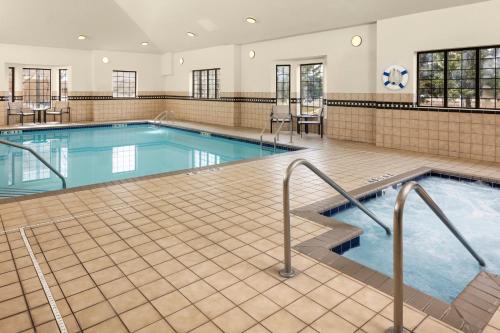 a large indoor pool with blue water in a building at Staybridge Suites Minneapolis-Bloomington by IHG in Bloomington