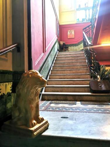 a statue of a bear sitting in front of a staircase at El Secreto Casa Art in Montevideo