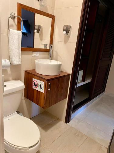 a bathroom with a toilet and a sink and a mirror at Hotel Nojoch che in Cobá
