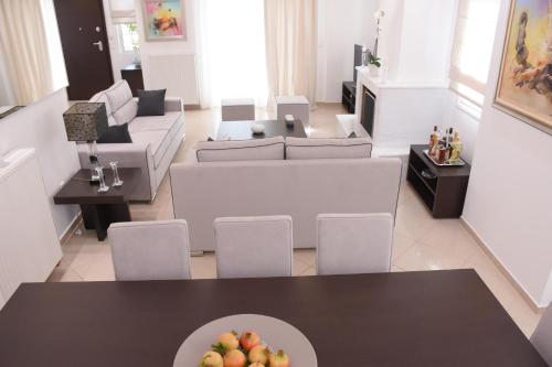 a living room with a table with a bowl of fruit at Keratea Luxury Villa -Athens Airport in Keratea