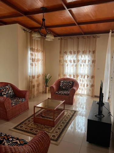 a living room with two chairs and a coffee table at Nicole Residence in Yaoundé