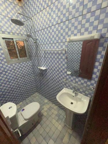 a bathroom with a toilet and a sink at Nicole Residence in Yaoundé