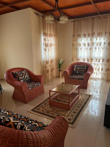a living room with two chairs and a coffee table at Nicole Residence in Yaoundé
