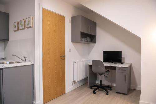 a room with a desk with a computer and a door at Modern Spacious Central Studio in Manchester