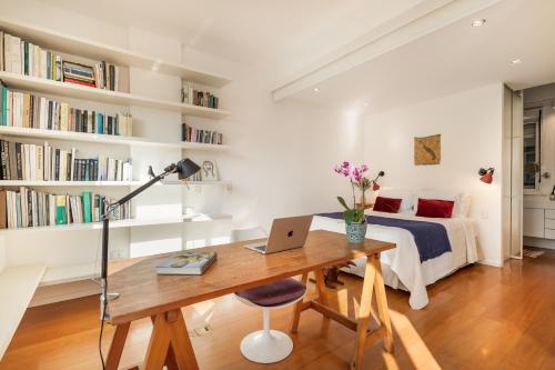 een slaapkamer met een bed en een bureau met een laptop bij Unhotel-Home Office Loft Vista para Lagoa in Rio de Janeiro