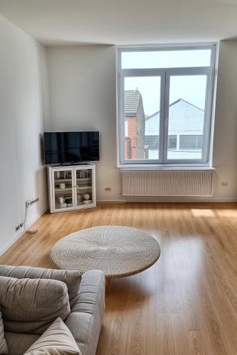 a living room with a couch and a large window at Jumet 242 B Bruxelles-Charleroi-airport in Charleroi