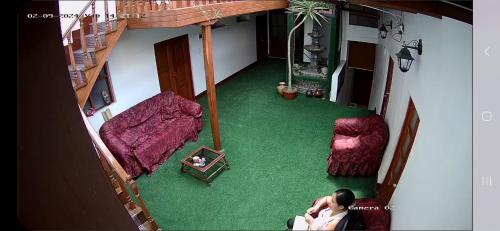 カハマルカにあるTaita wasiの緑のカーペットが敷かれたリビングルームの上から見渡せます。
