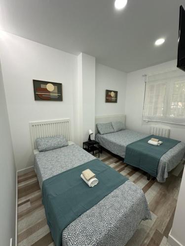 Habitación con 3 camas en una habitación en Alojamiento Fantasía, en Madrid