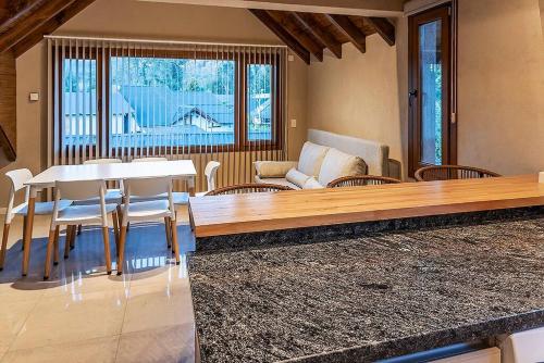 ein Wohnzimmer mit einem weißen Tisch und Stühlen in der Unterkunft Happy Host - Domo Paisajismo in Villa La Angostura