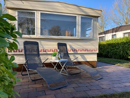 three chairs and a table in front of a tiny house at Chalet G5 it Soal Workum in Workum