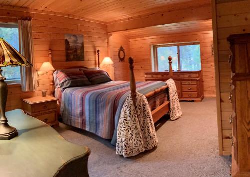 a bedroom with a bed in a log cabin at Hideaway Ranch in Bonners Ferry