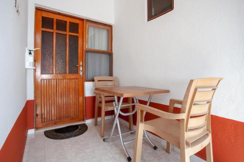 a table and chairs in a room with a door at Baris Pension & Bungalows in Cıralı