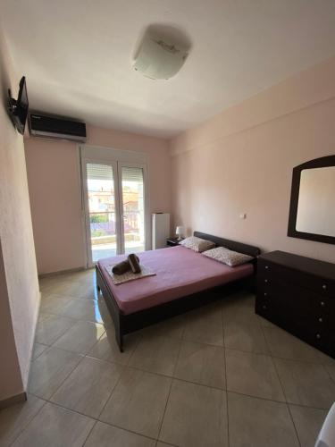 Un dormitorio con una cama con sábanas moradas y una ventana en Villa Marianna, en Nea Vrasna