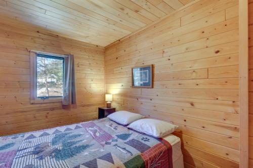 ein Schlafzimmer mit einem Bett in einem Blockhaus in der Unterkunft Dog-Friendly Park Rapids Retreat with Boat Dock! in Arago