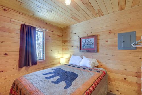 - une chambre avec un lit dans une cabane en rondins dans l'établissement Serene Park Rapids Cabin Fire Pit, Lake Access!, à Arago