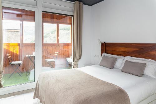 a bedroom with a large bed and a balcony at AndBnB I Cerca de Grandvalira con Terraza + Parking gratis in Soldeu