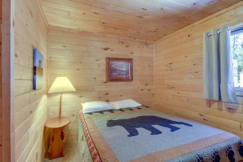 ein Schlafzimmer mit einem Bärenbett in einem Blockhaus in der Unterkunft Waterfront Park Rapids Escape with Charcoal Grill! in Arago