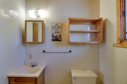 ein Badezimmer mit einem Waschbecken, einem WC und einem Spiegel in der Unterkunft Waterfront Park Rapids Escape with Charcoal Grill! in Arago