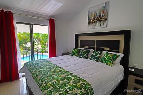 um quarto com uma cama grande e uma janela grande em 2-BD Unit with Pool 2 Blocks from Beach em Coco