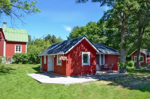 a red cottage with a red barn at Strandbergs Stugor in Mariehamn