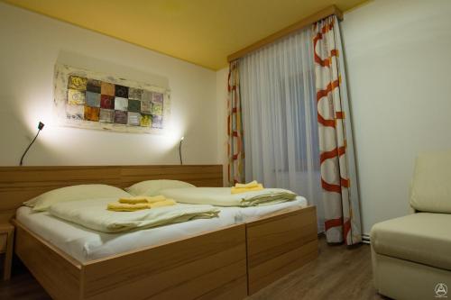 a bedroom with two beds and a window with a curtain at Egidiwirt Murau in Murau