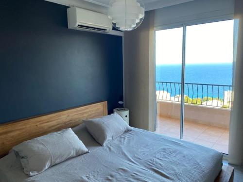 une chambre avec un lit avec vue sur l'océan dans l'établissement Appartement Bastia entièrement climatisé vue mer, à Bastia