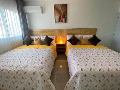 a bedroom with two beds and a candle in it at Room in Samana in Santa Bárbara de Samaná