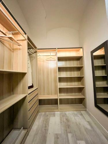 a walk in closet with wooden shelves and a mirror at Calosso Wine View Escape in Calosso