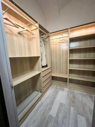 a walk in closet with wooden shelves and wooden floors at Calosso Wine View Escape in Calosso
