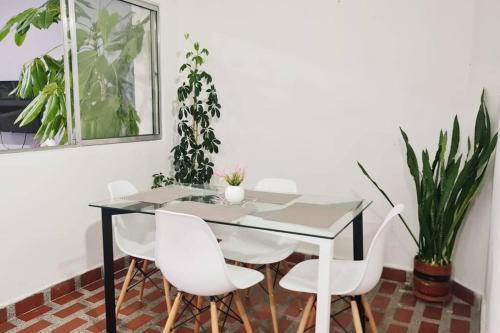 comedor con mesa de cristal y sillas blancas en Medellín Casa central Envigado frontera poblado en Envigado