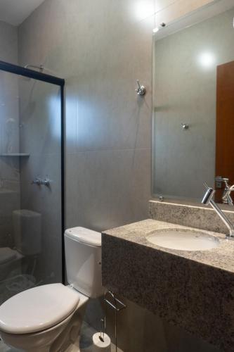 a bathroom with a toilet and a sink and a mirror at Amazon Green Hotel in Lucas do Rio Verde