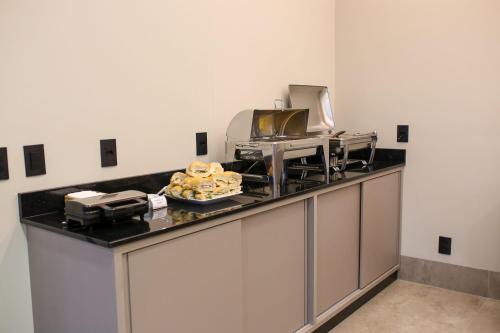 a kitchen with a counter with a plate of food on it at Amazon Green Hotel in Lucas do Rio Verde