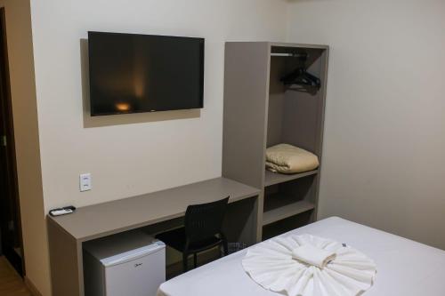 a room with a white table and a television on a wall at Amazon Green Hotel in Lucas do Rio Verde