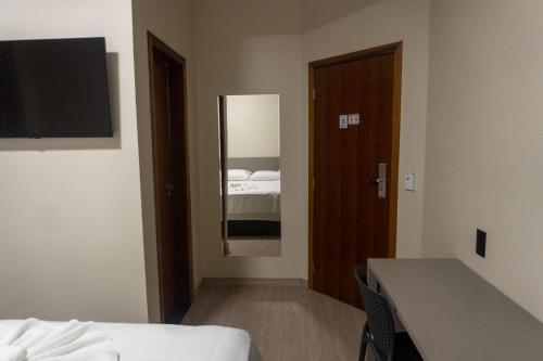 a room with a bedroom with a bed and a mirror at Amazon Green Hotel in Lucas do Rio Verde